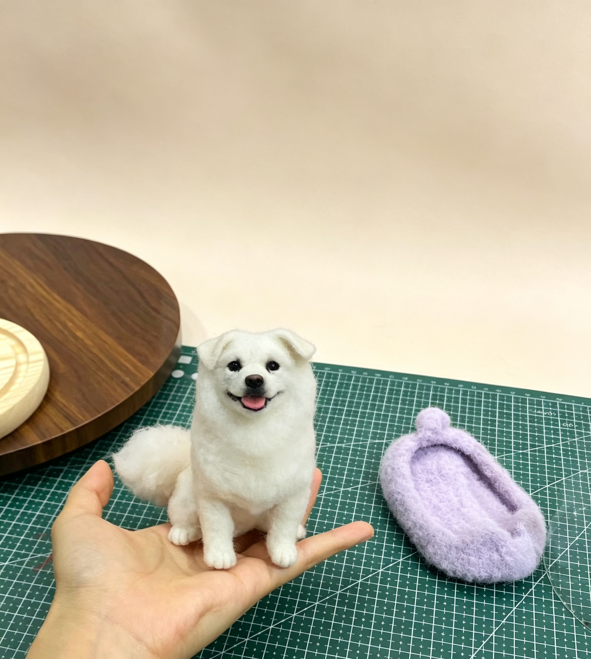 Palm-sized custom wool dog figure beside its handmade accessory